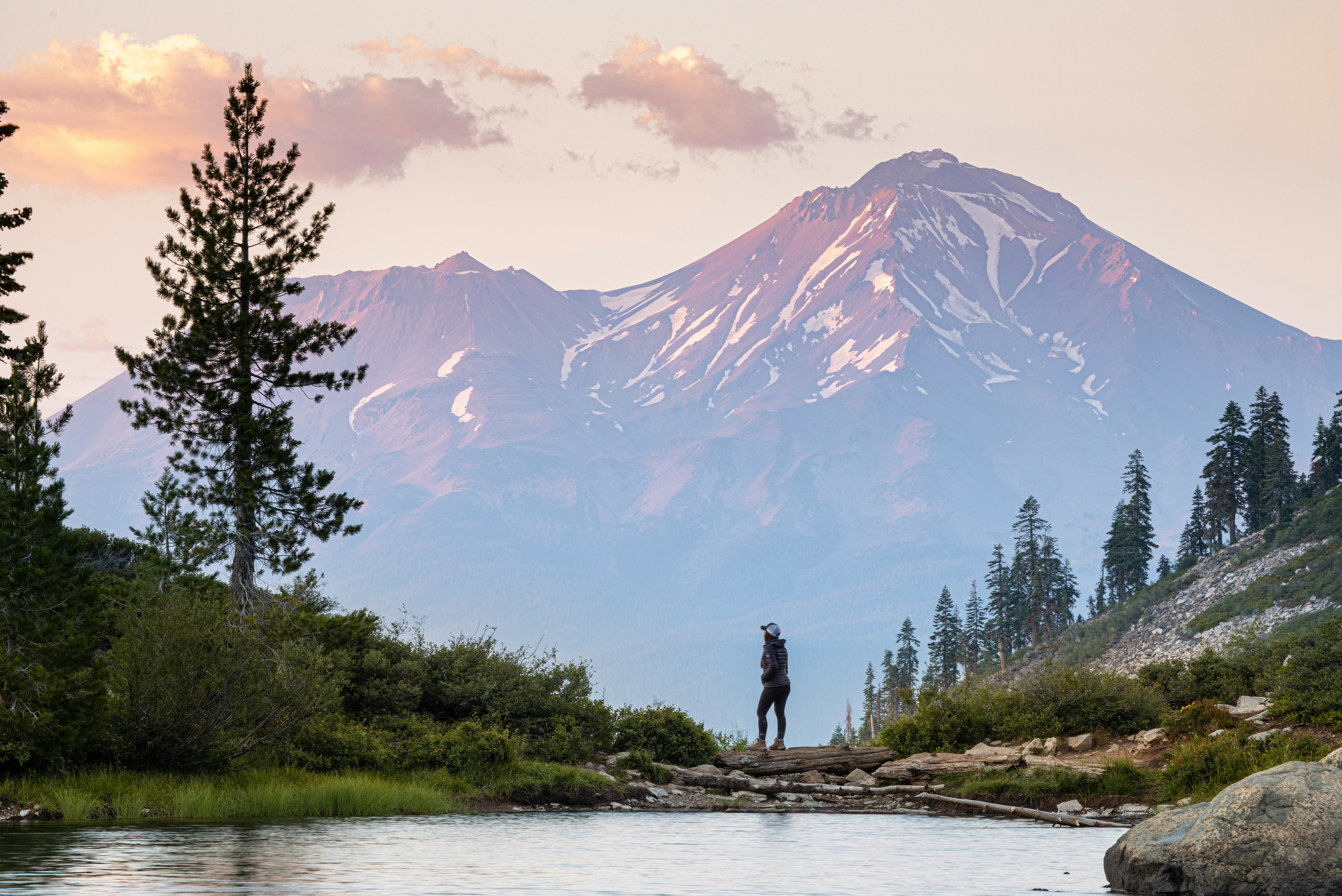 person standing on rock near body of water during daytime